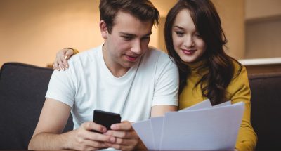 Couple discussing with financial documents and calculator in living room at home Couple discussing with financial documents and calculator in living room at home